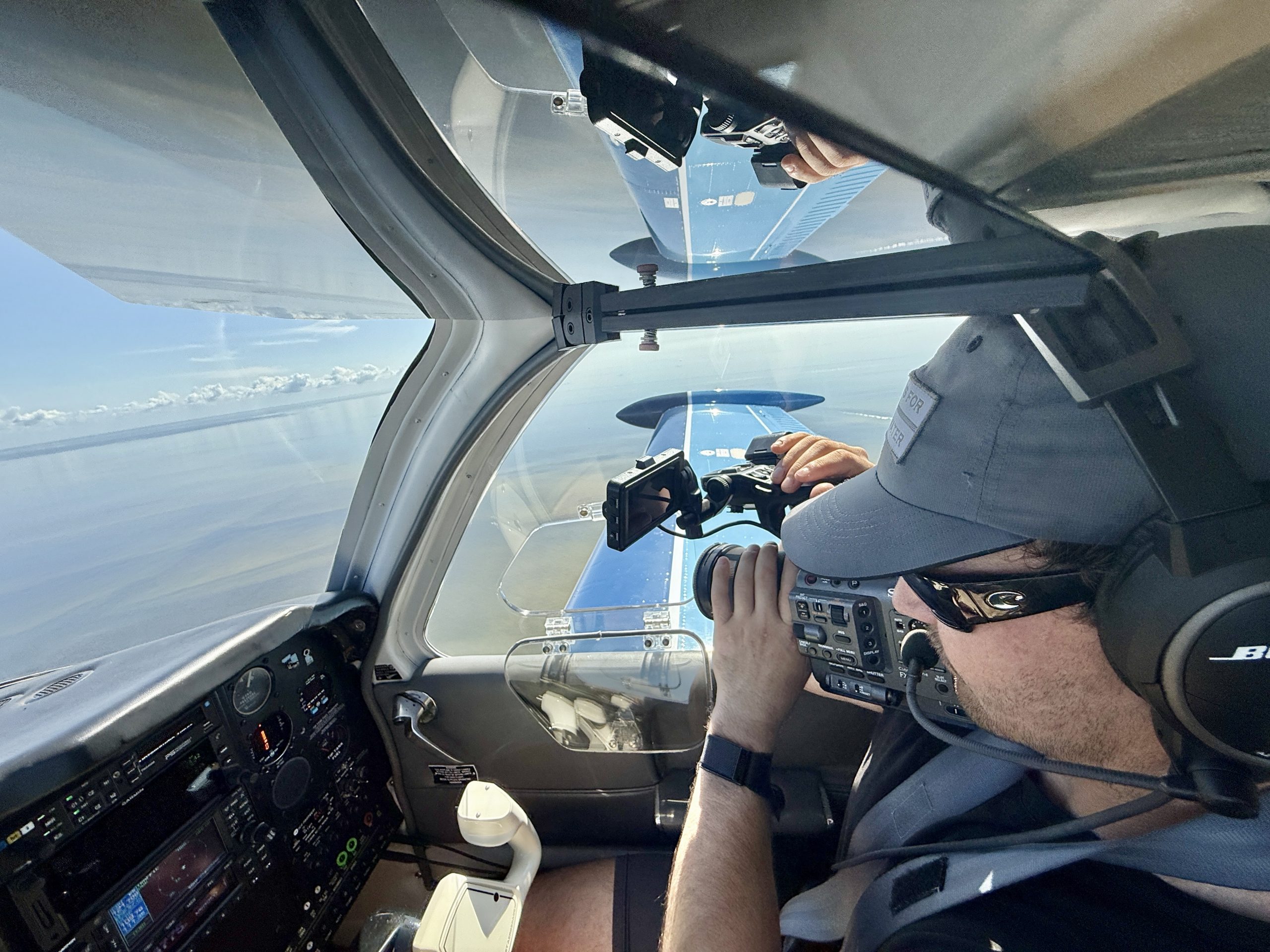 Videography capturing imagery through the window of a small aircraft flying over the coast of Florida.